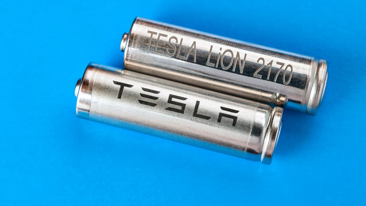 Two cylindrical battery with Tesla logo, for a pack of cells, on light blue background