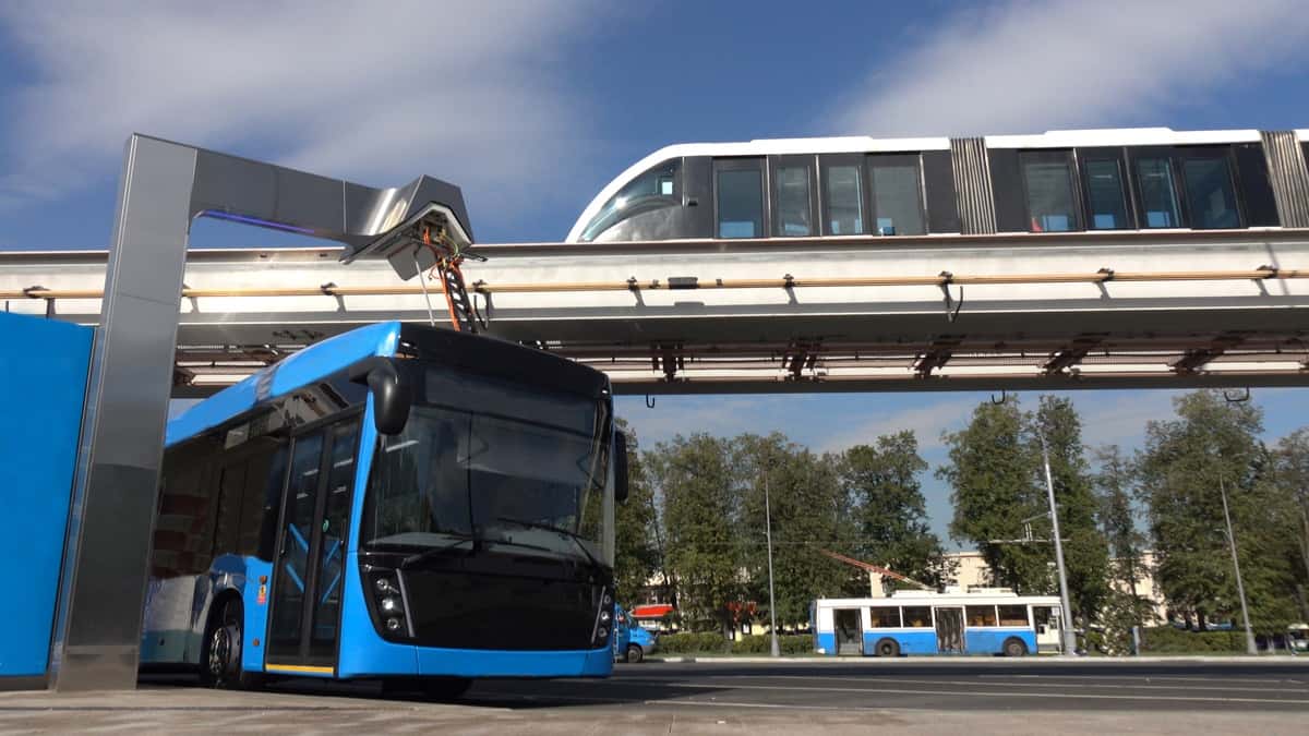 Blue electric bus at the charging station.Modern trains on the monorail