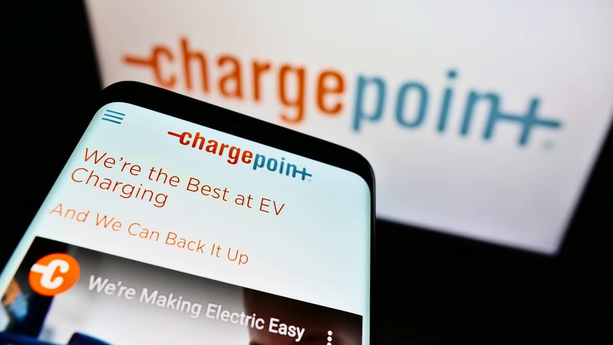 Cellphone with website of US electric vehicle charging company ChargePoint Holdings on screen in front of logo