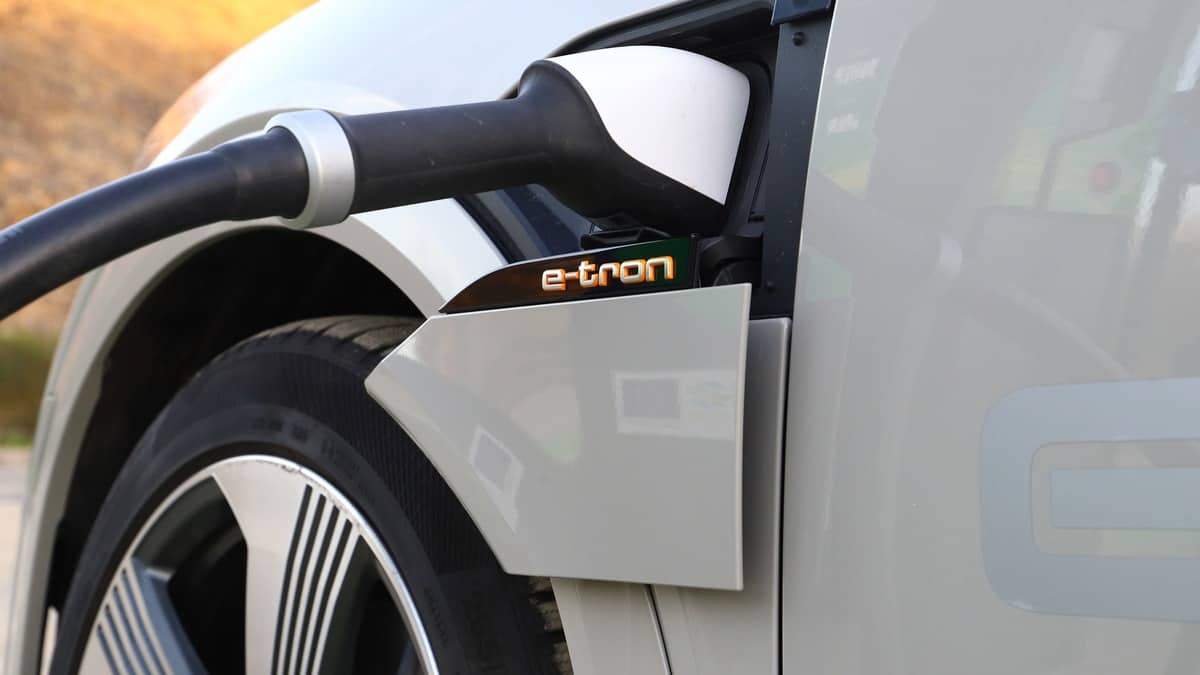 Electric SUV Audi e-tron plugged into a quick charger and being charged