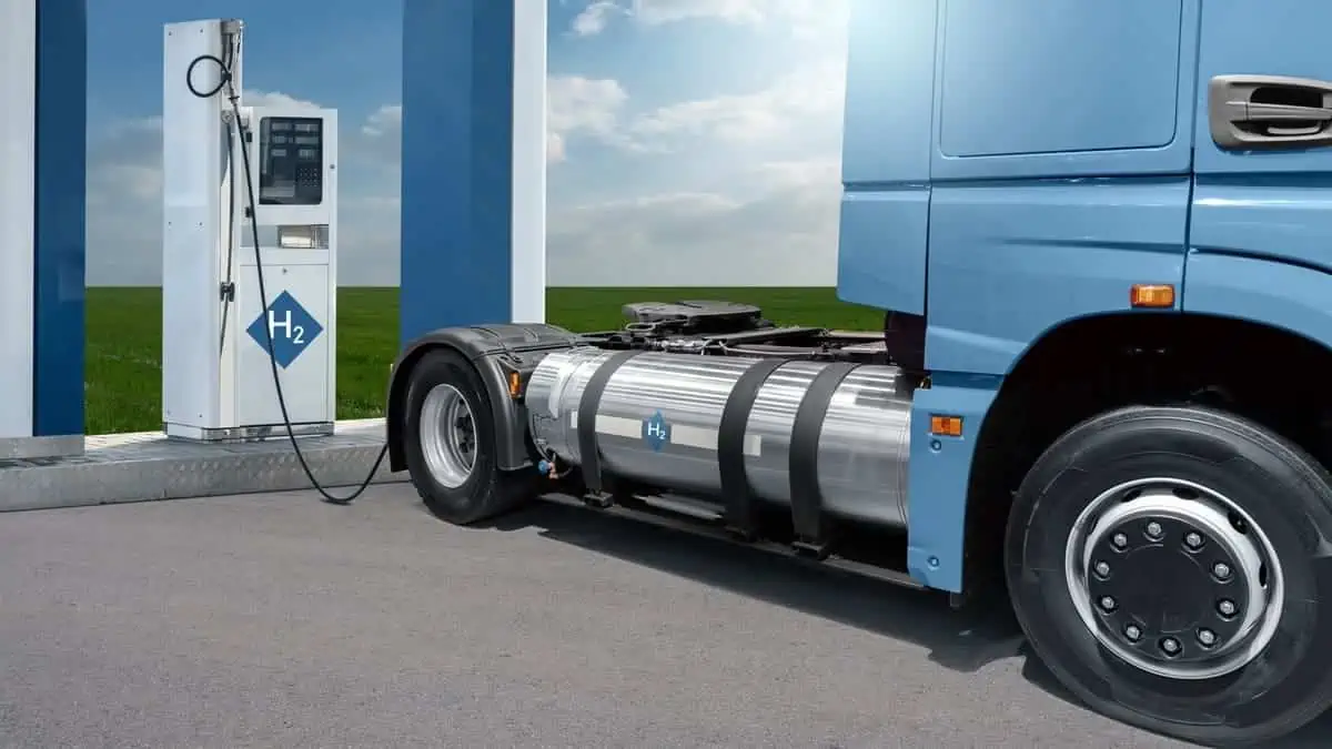 A hydrogen fuel cell semi truck with H2 gas cylinder onboard next to filling station. Eco-friendly commercial vehicle concept