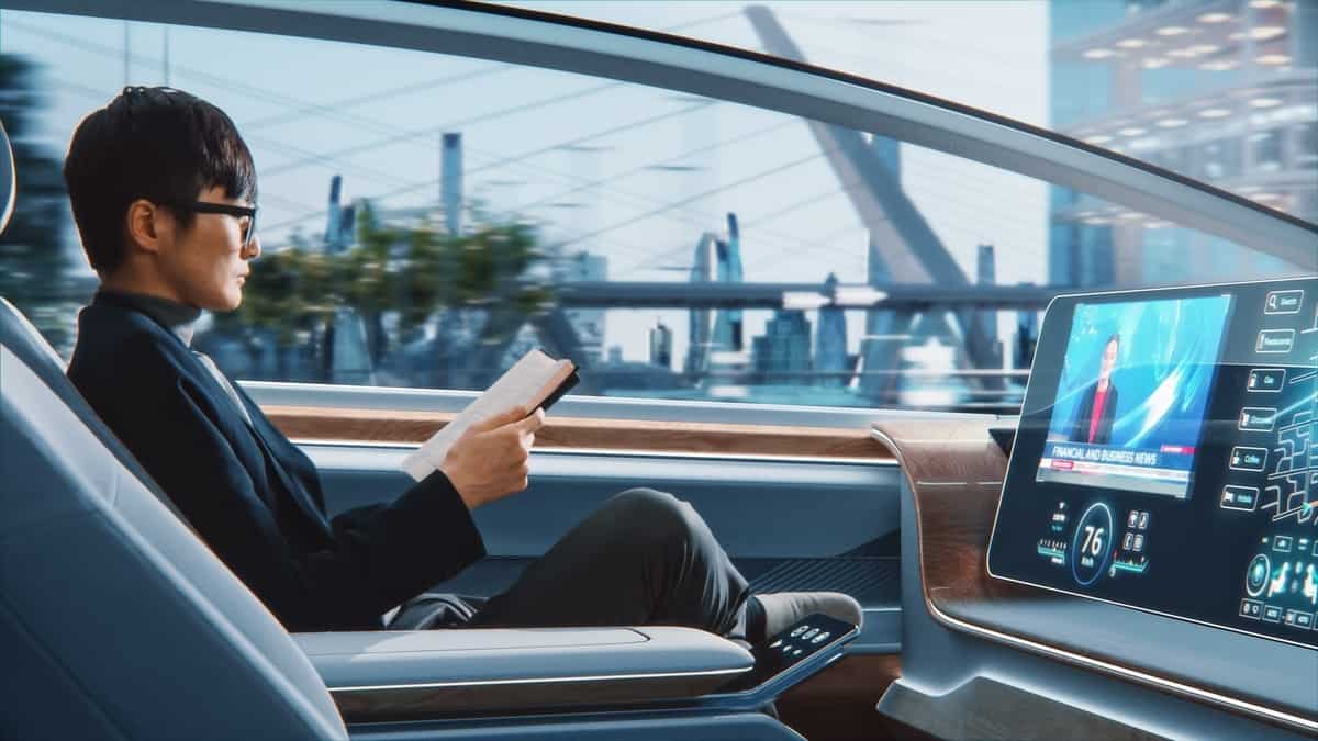 Futuristic Concept Handsome Stylish Japanese Businessman in Glasses Reading Notebook and Watching News on Augmented Reality Screen while Sitting in a Autonomous Self-Driving Zero-Emissions Car.