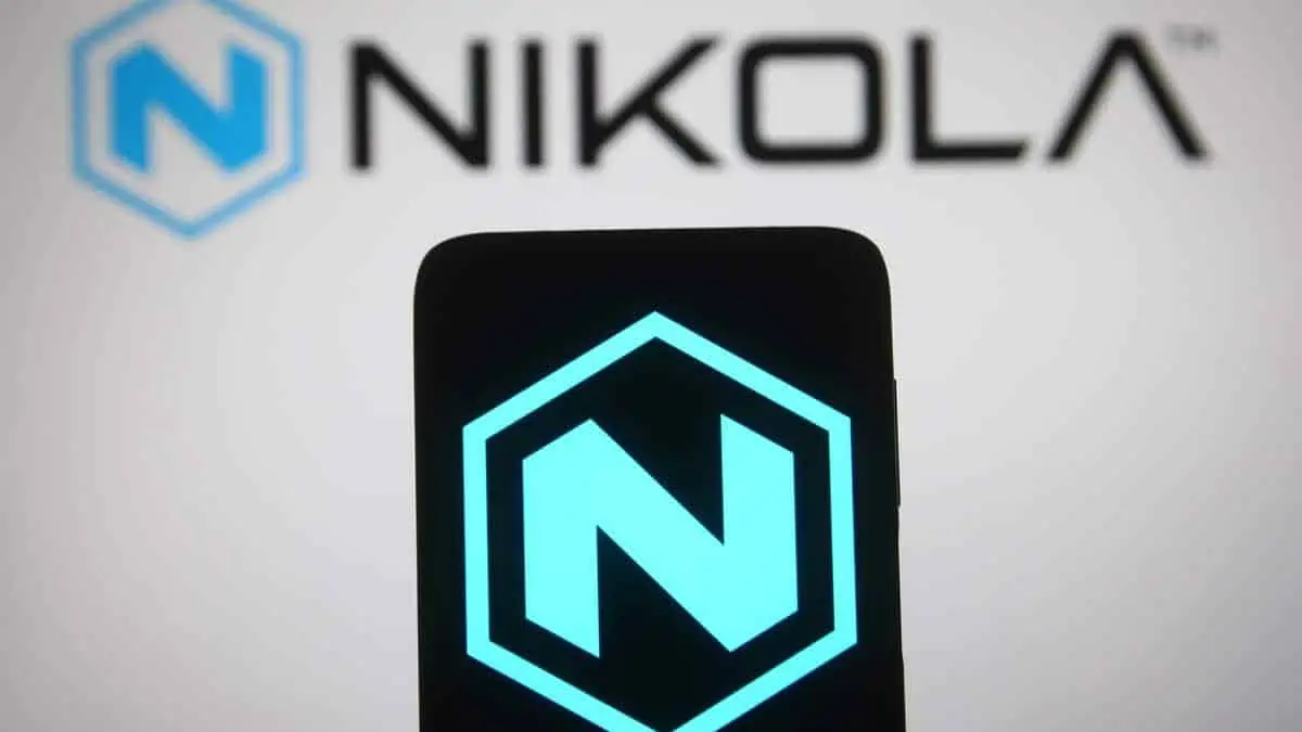 This photo illustration Nikola Corporation logo is seen on a mobile phone screen and background.