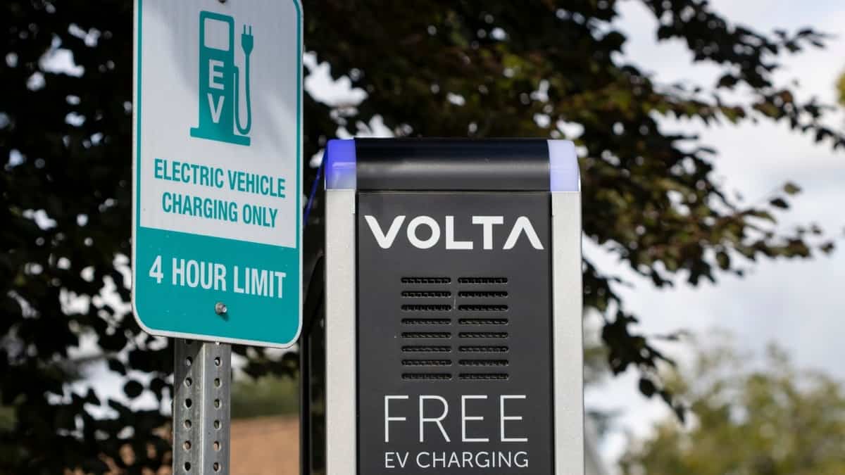 Tigard, OR, USA - Oct 6, 2021 Closeup of the Volta logo seen on the side of a kiosk next to a 4-hour limit parking space sign at a Volta free EV charging station in Tigard, Oregon.