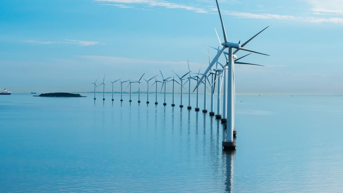 offshore windmill park alternative energy. windmills in the sea with reflection morning